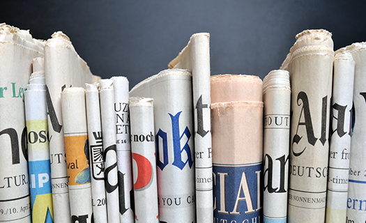 news-folded-newspapers-front-black-wall.png