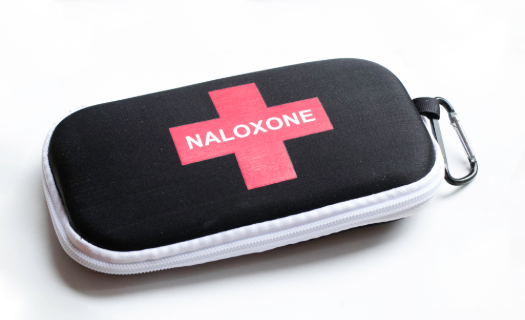Photo of a modern first aid kit with a red cross and the word NALOXONE on the front.