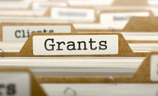 A file folder with a GRANTS label on the tab and papers inside. 