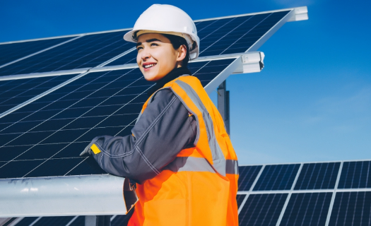 A worker installing solar panels on a sunny day.