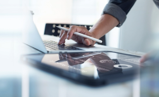 Person using a laptop and tablet for performance monitoring.