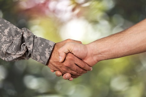 Person in uniform shaking hands with someone not in uniform