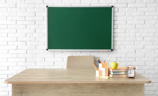 Teacher desk and chalkboard in classroom