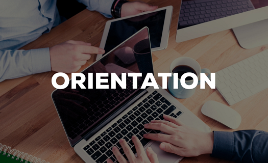 The word ORIENTATION as an overlay over a shaded office scene where a few people are working at a busy desk.